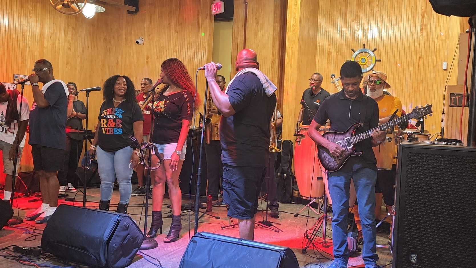 Nice & Smooth Music Group playing live — vocalists at the microphones with guitar, trumpet and percussion behind them